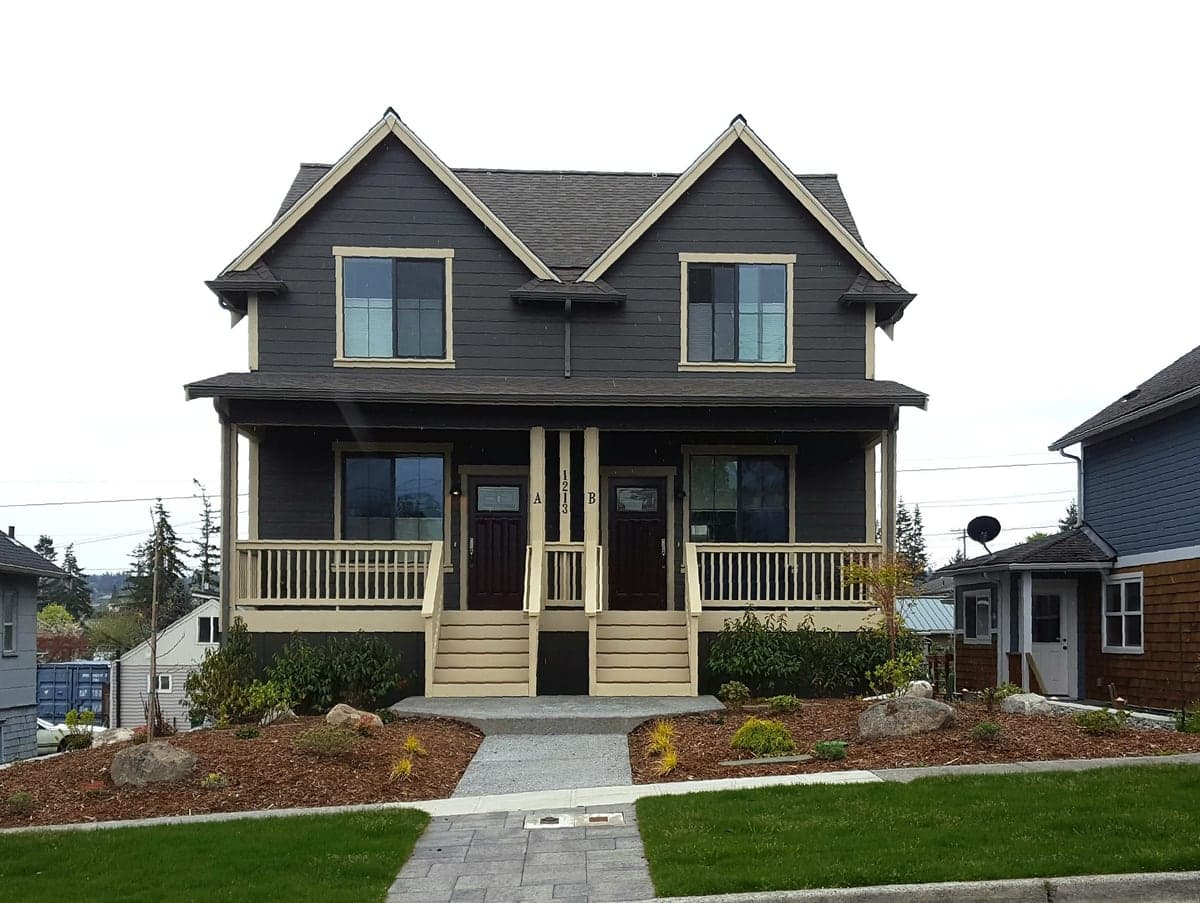 A side-by-side duplex with two front doors and a shared front porch — a classic example of middle housing that reads as a single-family home from the street.
